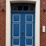 Stylized shot of a blue double door set in a red brick building, offering a classic architectural look.